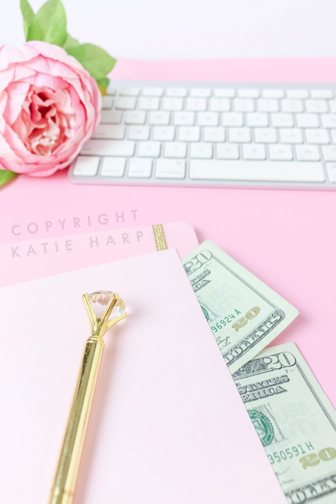 Pink notebook with money and a keyboard and flower