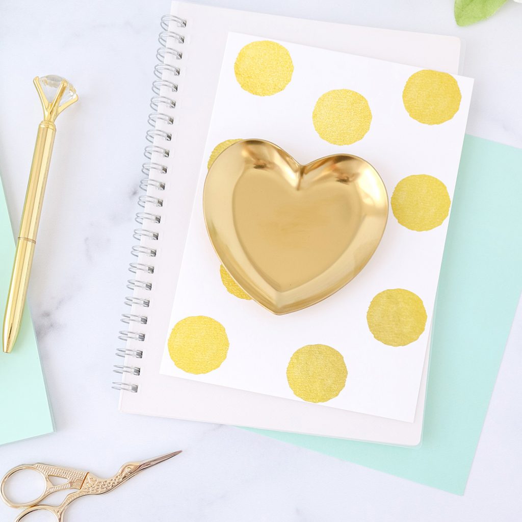 Picture of a gold heart with decorative notebooks and office supplies