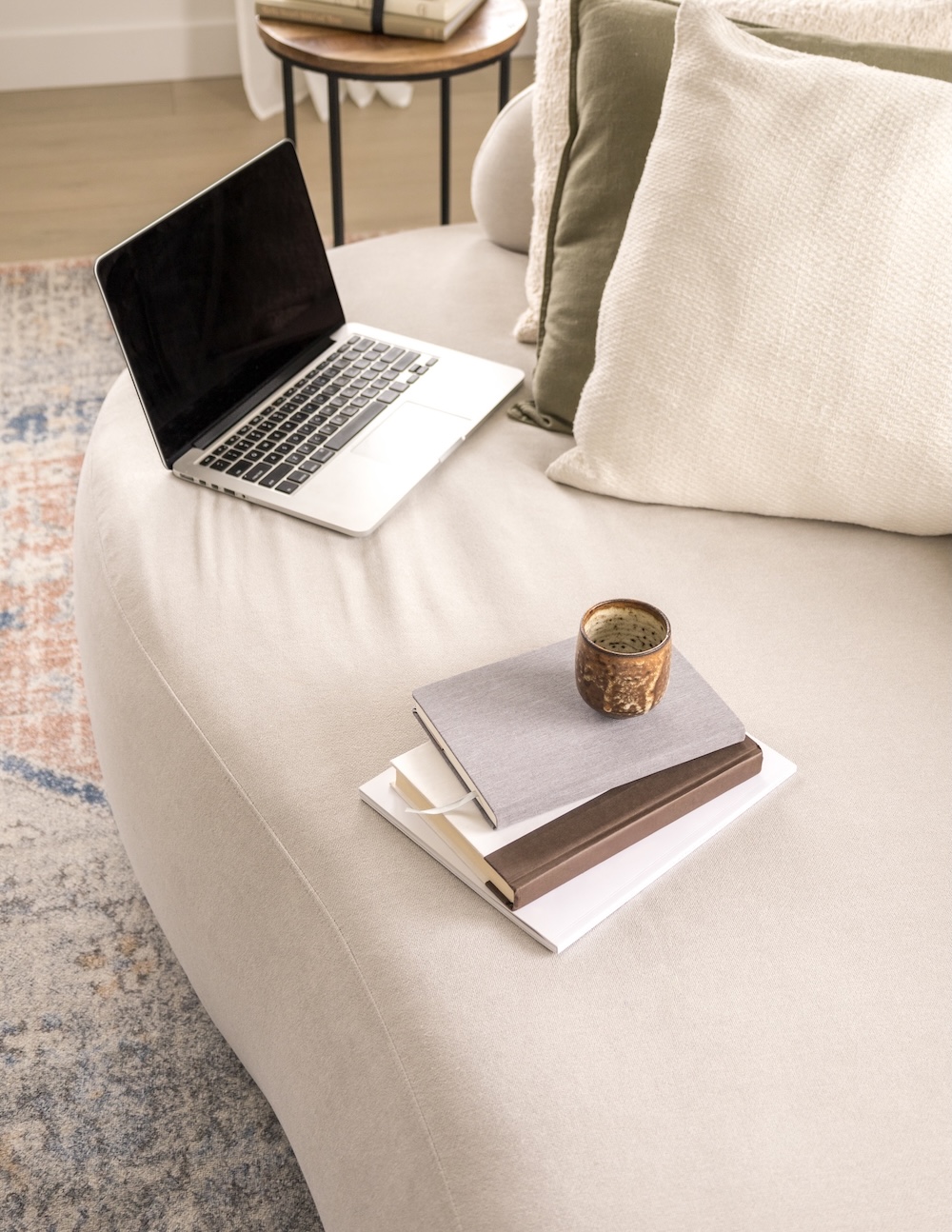 Laptop on a couch with a notebook